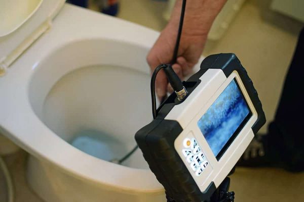 Checking clogged toilet pipe with inspection camera.